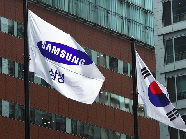 首尔,韩国国旗(右)与三星旗帜飘扬在三星公司一栋办公楼前。(新华/法新)