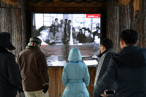 市民在公园内观看军事历史资料片