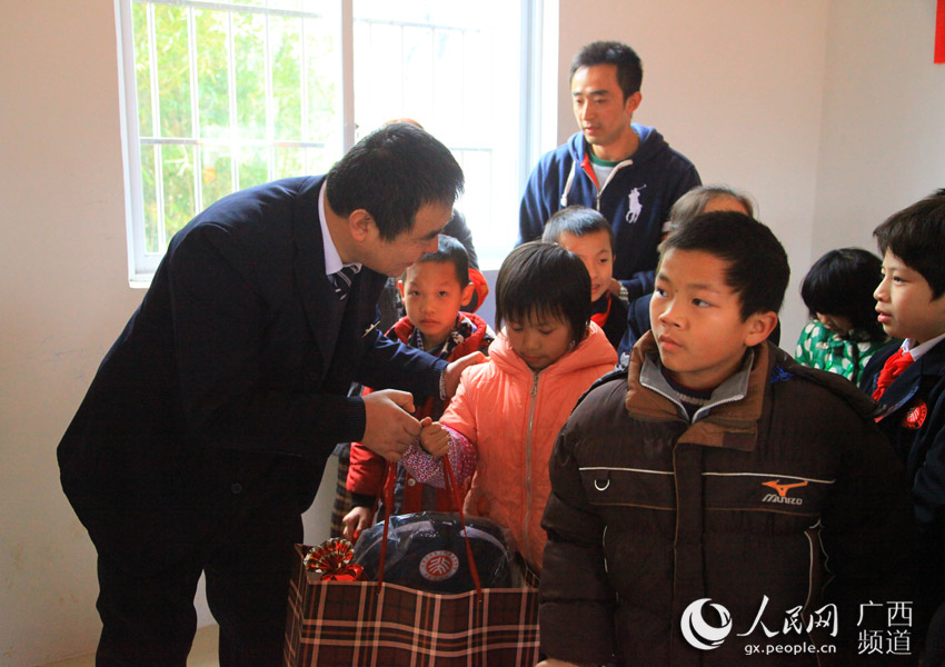 北京大学南宁附属实验学校副校长付博给孩子们送上礼物
