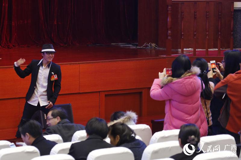 广西政协委员卓君在政协会议休会间隙为现场委员即兴表演