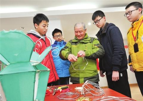 昨天,灯彩大师汪筱文为双塔街道百步街社区学生教授元宵花灯制作技巧。 □记者徐志强 摄