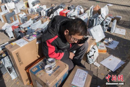 11月13日,山西太原高校校园内,快递公司在一片空地上按序堆满快件,等待大学生前来领取。 韦亮 摄