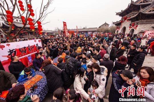 资料图:春节期间,河南建业大食堂吸引众多游客游庙会,吃小吃,拉动消费