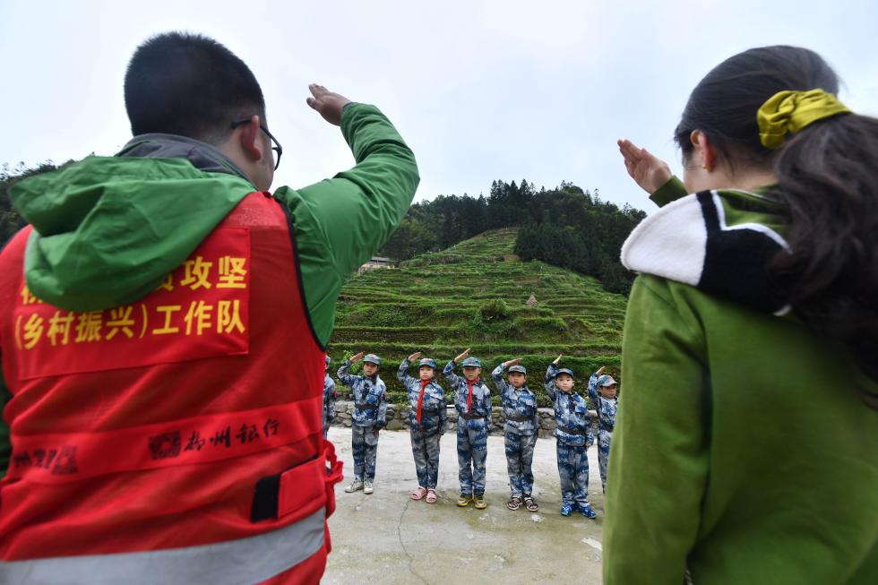 郑昌昊和吴晗带领学生了解苗寨的变化(4月14日摄.