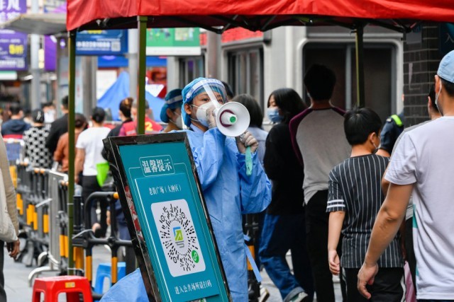 3月13日，在深圳罗湖区东门广场核酸检测点，志愿者在引导居民。新华社发 储焱 摄