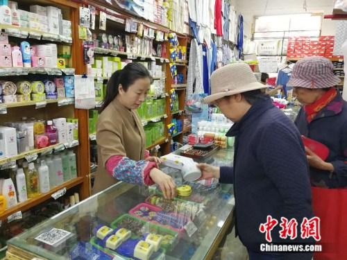 顾客在永安路百货商场化妆品柜台挑选商品 中新网记者 张尼 摄