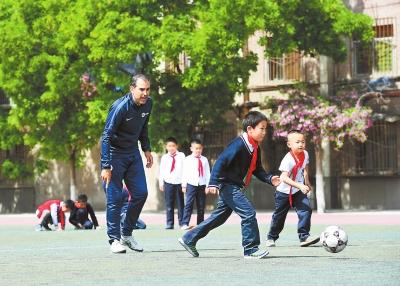 兰州市东郊学校的西班牙外教拉法给学生上足球课