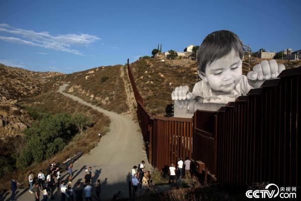 法国艺术家在美墨边境线创作 萌娃扒隔离墙