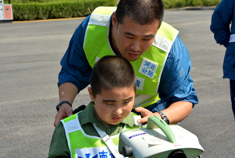 潘禹辰小朋友在爸爸潘圣卿的指导下操作测绘仪器。在潘禹辰小朋友的眼里，身为南水北调一名工程师的爸爸就是一个超人。（人民网记者孙博洋摄）