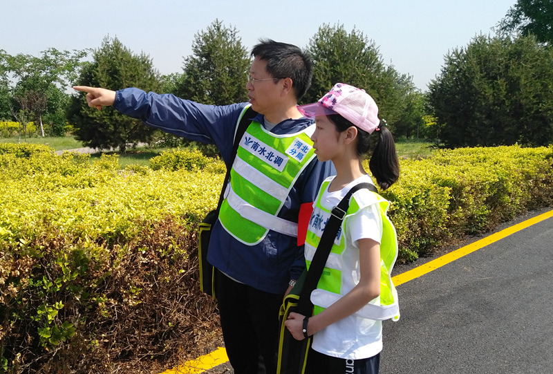冀海河在河北分局工程管理处，负责南水北调中线河北段工程的运行、在建项目质量、安全生产管理以及防汛应急工作。今年“六一”儿童节，冀海河决定做个不再“爽约”的老爸。按照约定，他带着上六年级的女儿冀妍冰来到了石家庄段工程渠道边，让女儿真切地体验一次老爸的日常工作。（韩霄 摄）