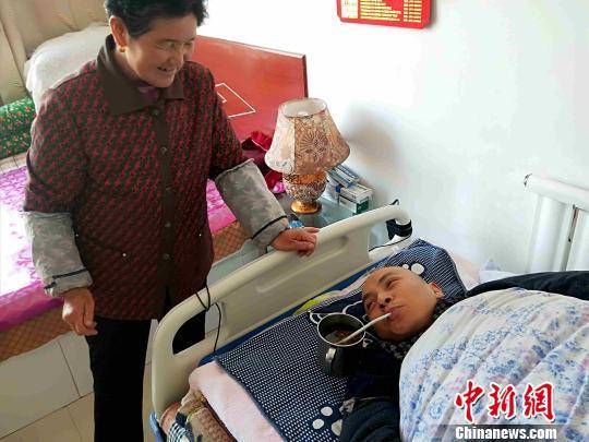 图为母亲照料都海成。 李隽 摄 图为母亲照料都海成。 李隽 摄