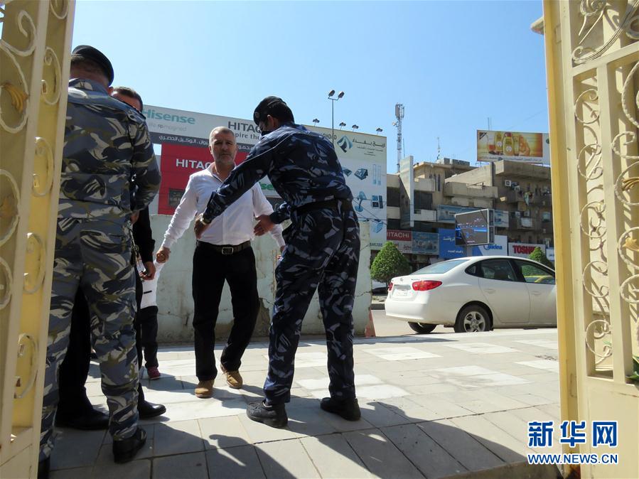 4月16日,在伊拉克巴格達,警察在一所教堂門口對一名男子進行安全檢查.