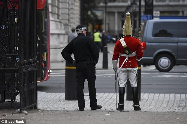 伦敦一士兵站岗时带耳机与身上制服形成鲜明对比