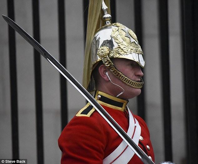 伦敦一士兵站岗时带耳机与身上制服形成鲜明对比
