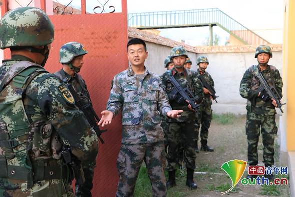 陆军某旅连长吴志辉为武警新疆总队某支队官兵讲解小组协同战术.