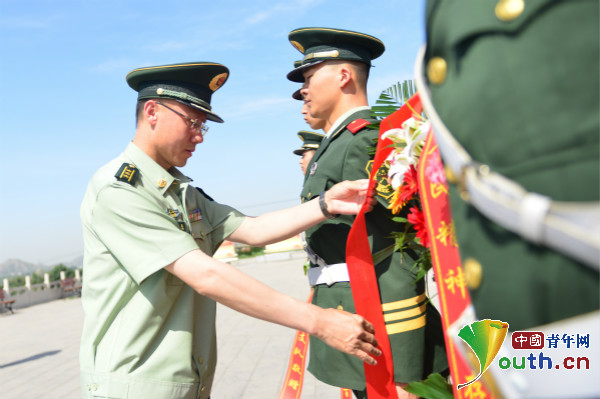 支队雒金龙政委整理花篮绶带.中国青年网通讯员 袁浩翔 摄