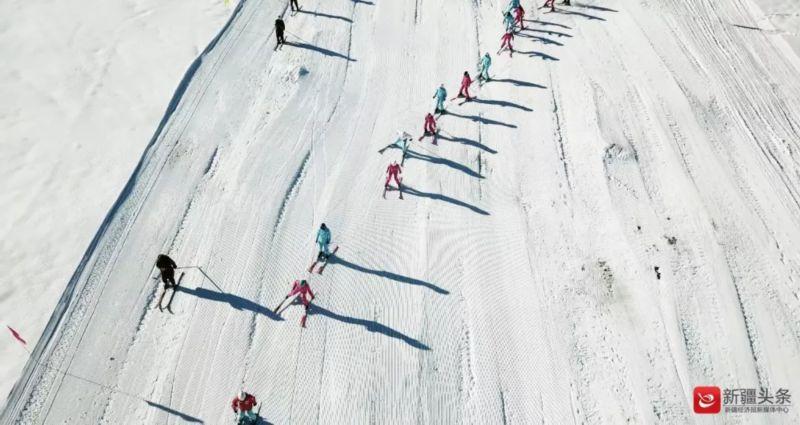 新疆阿勒泰阿尔泰山野雪公园,高山滑雪运动员手持火炬从山顶滑下