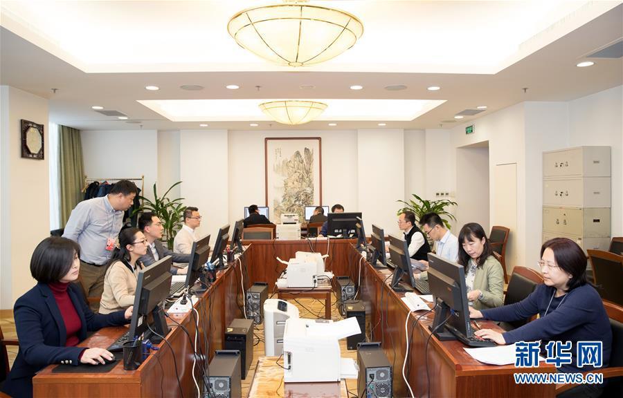 3月12日,十三届全国人大二次会议秘书处工作人员在认真工作.