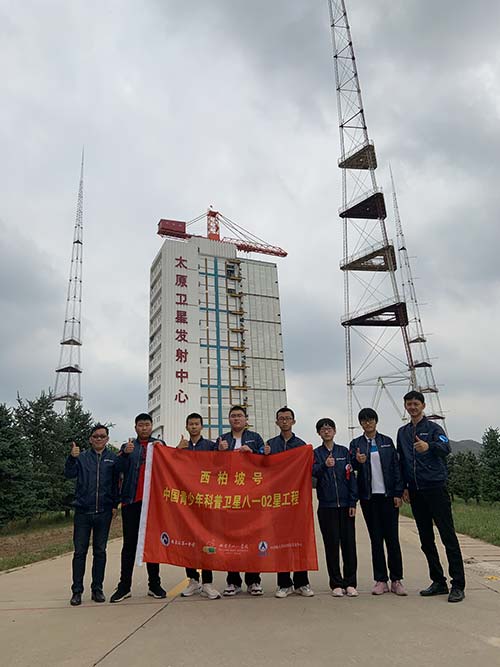 部分卫星参研学生在太原卫星发射中心发射塔架前合影.