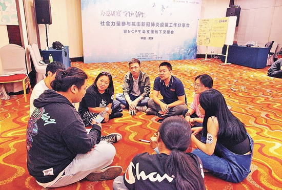 志愿者围坐讨论战"疫"经历