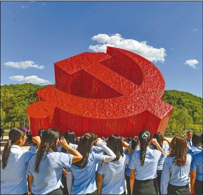 延安市宝塔区南泥湾镇党徽广场,共产党员们在重温入党誓词.