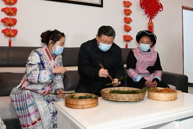 2021年2月3日下午,习近平在贵州毕节市黔西县新仁苗族乡化屋村苗族村民赵玉学家,同一家人边聊家常边制作当地传统节日食品黄粑。新华社记者 李学仁 摄